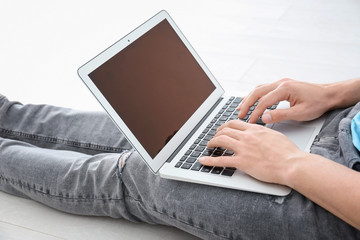 Fototapeta premium Man using laptop while sitting on floor