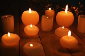 Burning candles on wooden table