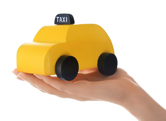 Fototapeta premium Woman holding yellow toy taxi cab on white background, closeup