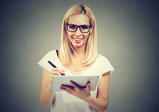 Closeup portrait of a cheerful woman working with stylus and digital tablet pc