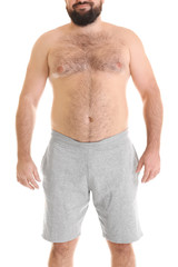 Overweight man in shorts on white background