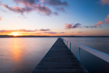 Sunset view of long jetty into the lake.