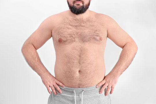 Overweight young man on light background