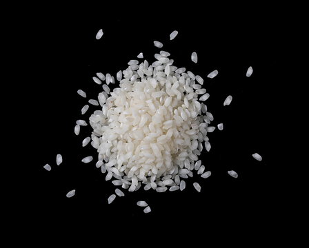 White rice pile isolated on black background, top view