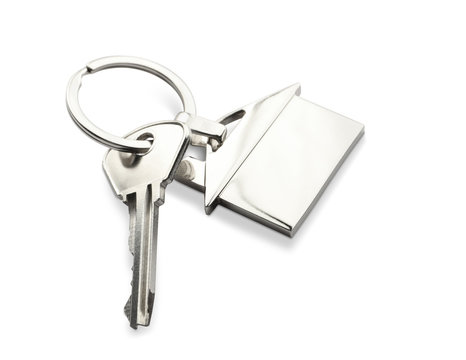Key with trinket in shape of house on white background