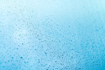 Blue background of rain drops on a window