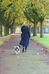 woman and dog walking and playing in the park