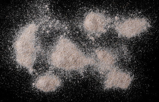 Pile of integral whole grain barley flour isolated on black background and texture, top view, with clipping path 