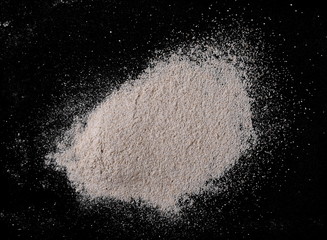 Pile of integral whole grain barley flour isolated on black background and texture, top view, with clipping path 