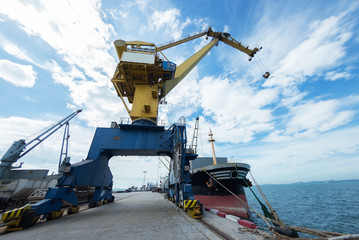 Industrial crane loading Containers in a Cargo freight ship.