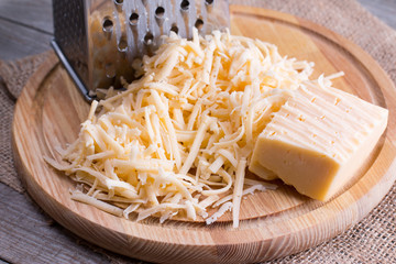 Grated cheese on a wooden cutting board