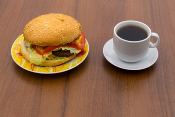 Delicious hamburger and cup of coffee on wooden table