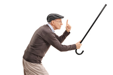 Angry senior holding his cane as a sword and gesturing with his finger