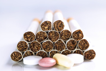 Cigarette and Medicine on a white table.