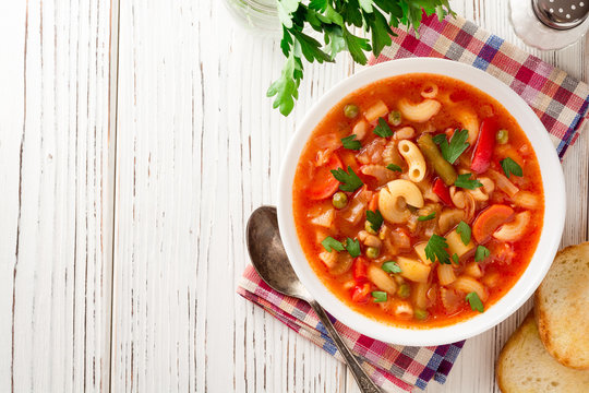 Italian minestrone soup on white wooden background.