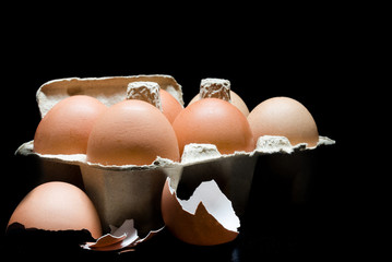Eggs in cardboard on black background