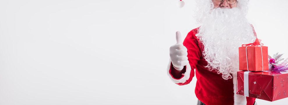 Panoramic image of Santa Claus show thumb up and giving gift box on white background with copy space,Christmas decoration holiday party. Merry Christmas and happy new year concept