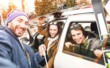 Best friends having fun taking selfie at car for ski and snowboard on mountain trip - Friendship...