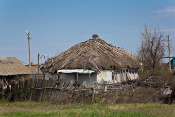 Fototapeta na wymiar Abandoned Russian village. Ruins of rural house with thatched roof