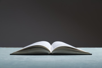 Composition with vintage old hardback books, diary, fanned pages on wooden deck table and red background. Books stacking. Back to school. Copy Space. Education background.