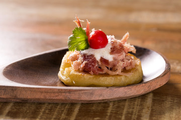 blinis of puba dough, smoked meat, coriander and minced pepper