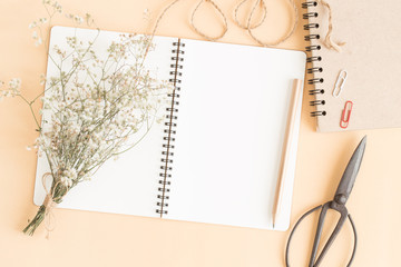 flat lay image of workplace with empty notebook,Yellow paper ground with notebook with pencil and old scissors