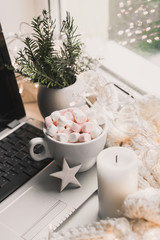 Cup of hot chocolate and marshmallow in the background of Christmas decorations.