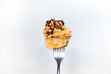 Single piece of nuts cake on fork ready to be eaten.