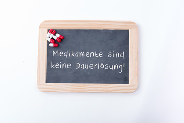 Medikamente sind keine Dauerlösung auf einer Tafel mit Pillen