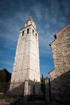 Aquileia, campanile della Basilica di Santa maria Assunta con cielo azzurro di sfondo