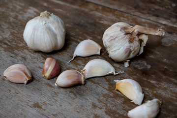 Fresh Garlic bulb, the raw garlic on the wooden background. Around the world, people used garlics in every cuisine. It can used as an effective form of plant-based medicine in many ways.