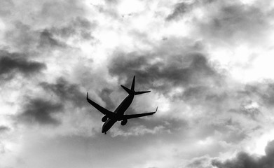 Airplane flying. Skyward view on a stormy day