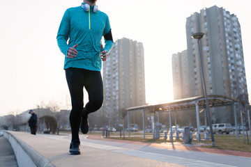 Young fitness man running in urban area