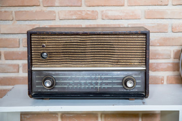Obsolete radio on wooden, brick wall background