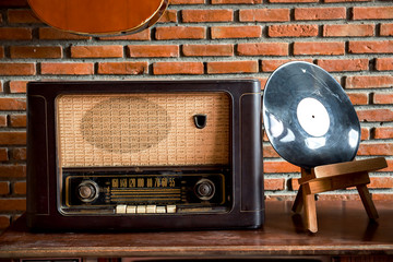 Obsolete radio on wooden, brick wall background