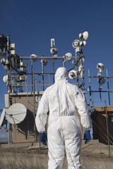 Man who works in a white suit and blue gloves, antennas