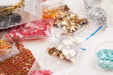 Different colour beads for handcraft and beading in plastic packages on a white background