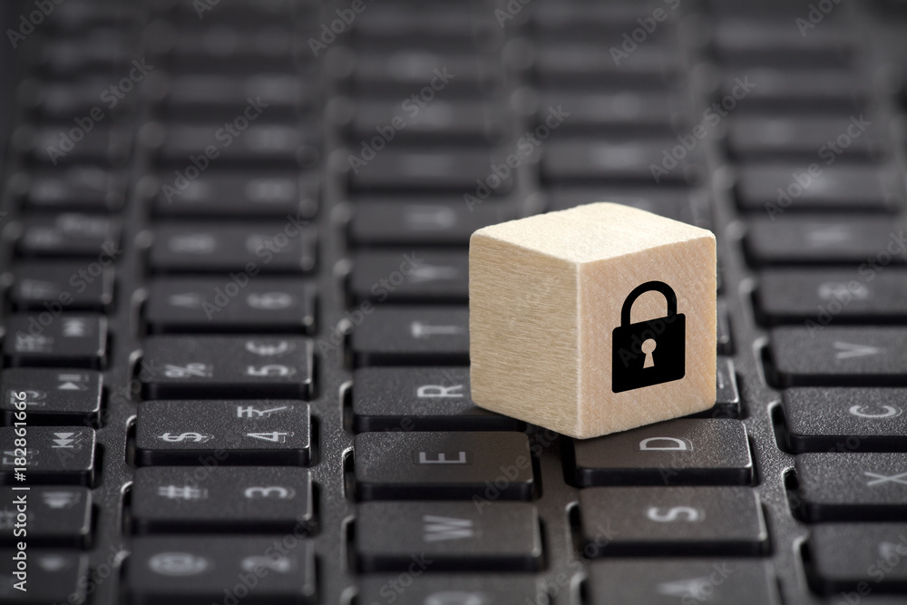 Aufkleber wooden block with lock graphic on laptop keyboard. computer security concept.
