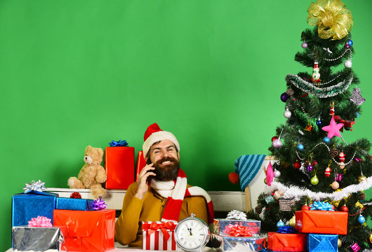 Santa Claus talks on mobile phone on green background - Powered by Adobe