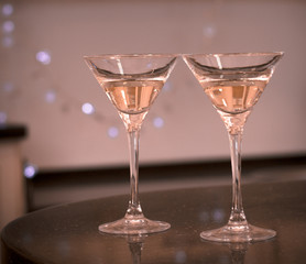 Still life with two glasses of champagne on a black table. Close up. Warm colors. Sepia background.