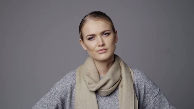 Sullen woman showing no gesture, isolated on grey background