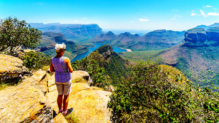 Fototapeta premium Senior woman enjoying the view of the Blyde River Canyon and Blyde River Dam from the viewpoint at the Three Rondavels along the Panorama Route in Mpumalanga Province of South Africa