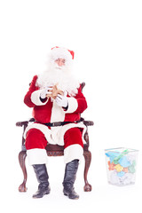 Bad Santa Claus reading letters from kids, crumpling them and throwing into trash basket