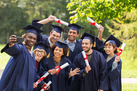 students or graduates with diplomas taking selfie