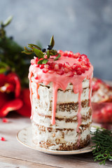 Festive honey cake with pomegranate seeds on wooden background