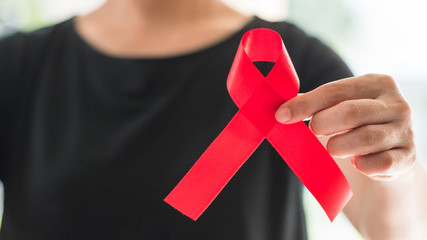 World aids day and national HIV/AIDS and aging awareness month concept with red satin ribbon on...