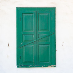 One green windows on a white wall