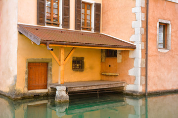 Fototapeta na wymiar City of Annecy. Fragment of a historic medieval house door with access to the Tue Canal in the resort and tourist town of Annecy in France on a summer day.