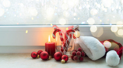 Christmas scene with one burning candle and christmas decorations on winter windowsill banner