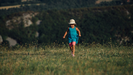 Little girl enjoy in dandelion field